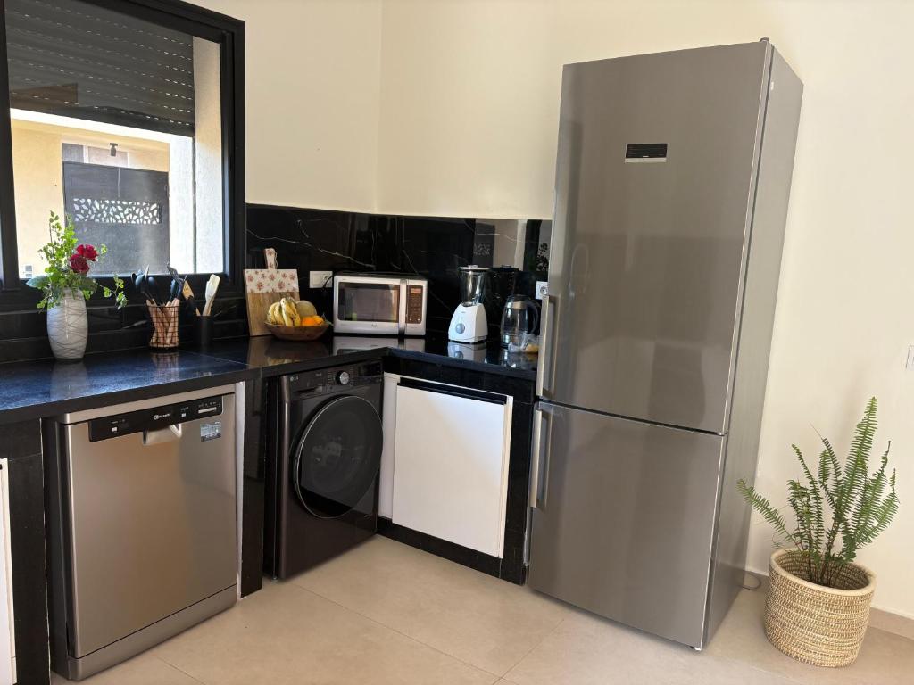a kitchen with a stainless steel refrigerator and a dishwasher at Villa Émeraude in Marrakesh