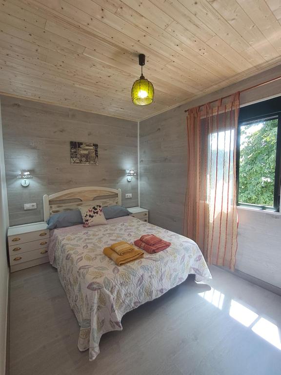 a bedroom with a bed with a wooden ceiling at O LAR DO SIL - Ribeira Sacra in Villar de Cerreda