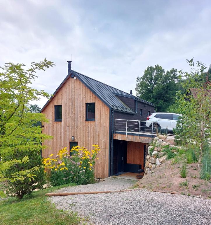 a wooden barn with a car parked on a bridge at Chalet Víchová se saunou in Víchová nad Jizerou