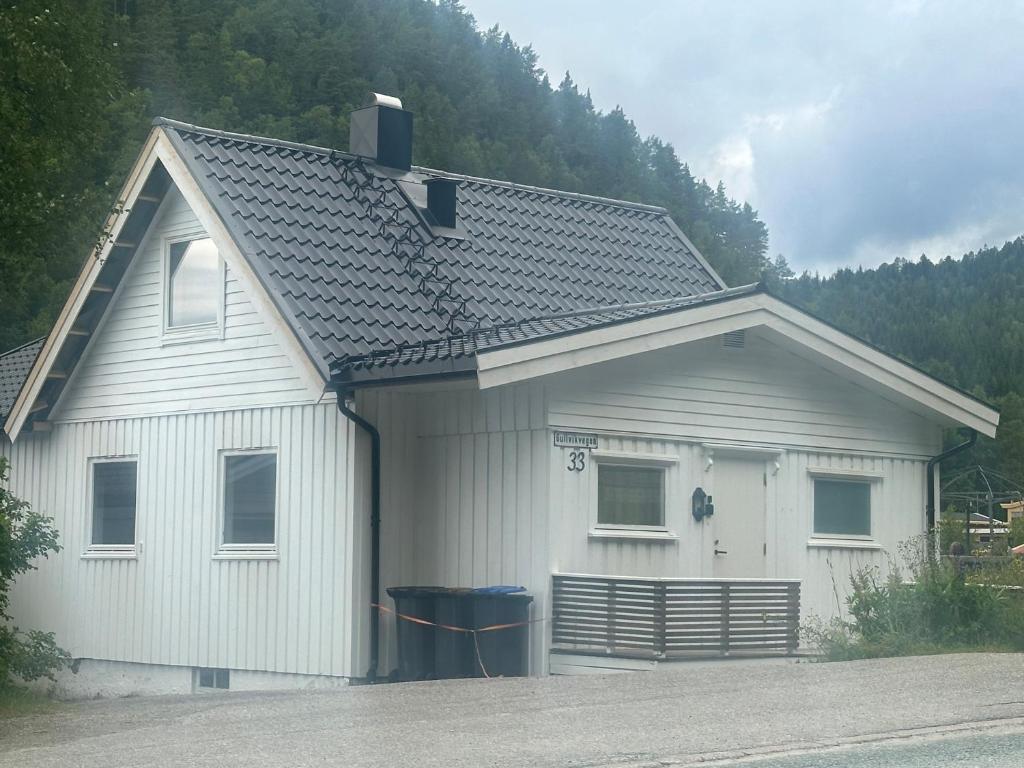 a white house with a gambrel roof at Gullvikvegen 33 in Namsos