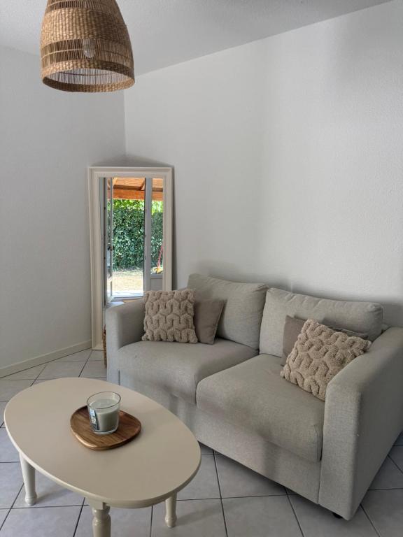 a living room with a couch and a table at Pavillon Le Luc in Ozillac