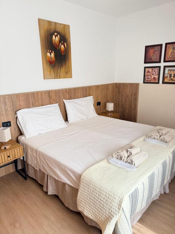 a bedroom with two beds with towels on them at Melannie's Apartment in Bergamo