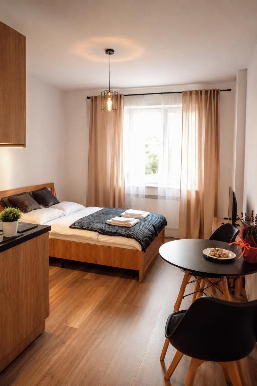 a bedroom with a bed and a table and a window at Apartament w Parku 5 in Żywiec