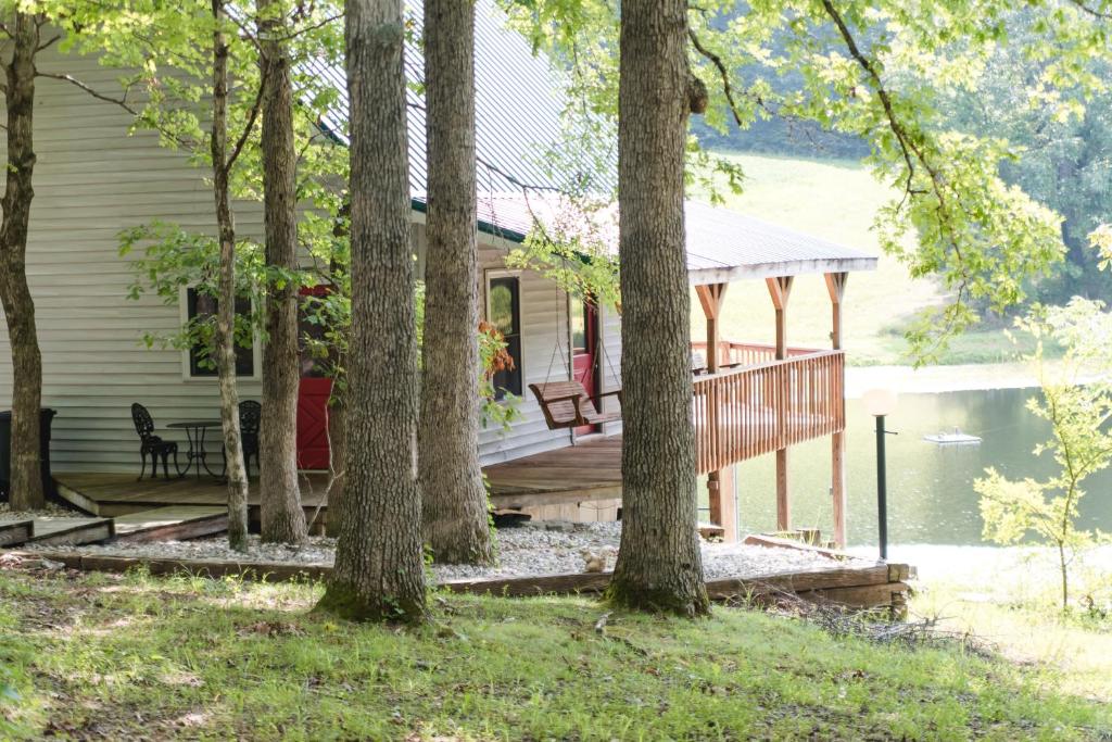 ein Haus mit einer Terrasse und Bäumen in der Unterkunft The Lake House A Hidden Gem Sleeps 4 in Columbia