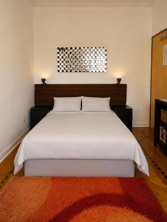 a bedroom with a large white bed with a red rug at Parque das Nações Room in Lisbon
