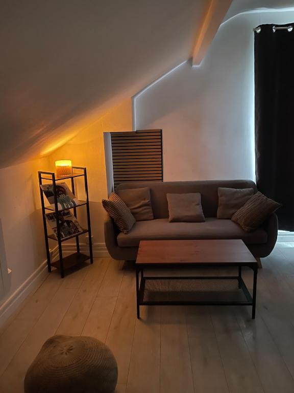 a living room with a couch and a table at Proche métro Line 4 RER B in Bagneux