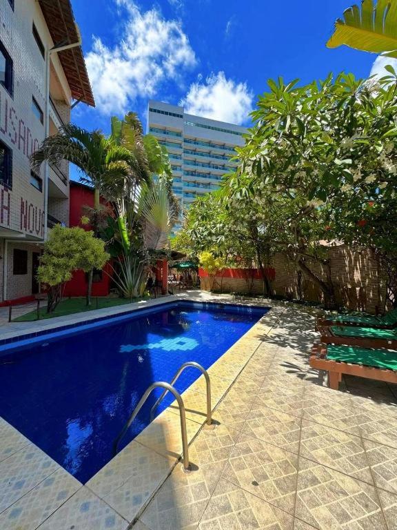 a swimming pool in front of a building at Pousada Legno Bossa Nova in Maceió