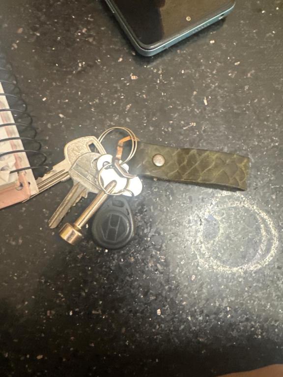 a pair of keys on the ground next to a cell phone at Manwel el ga7d in Giza