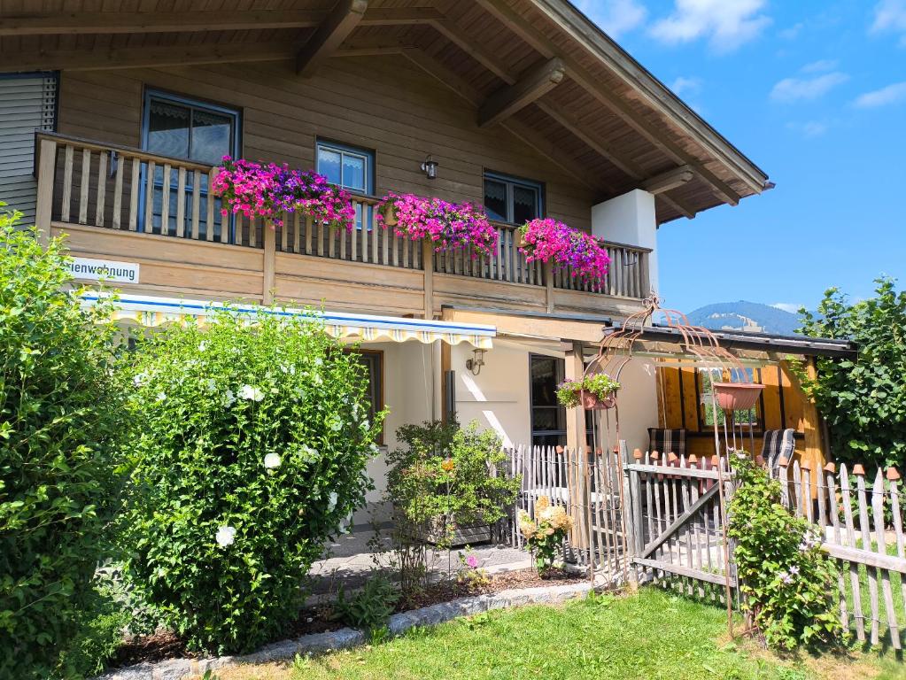 a house with a balcony with flowers on it at Ferienwohnung Oswald in Unterammergau