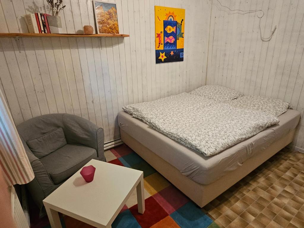 a small bedroom with a bed and a chair at Unser Hasenstall in Wietzendorf