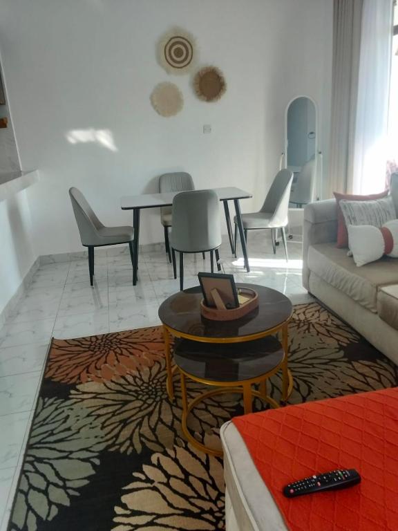 a living room with a couch and tables and chairs at MahaliaLuxuryStays in Malindi