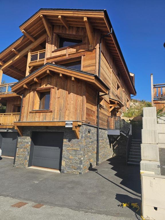 a large wooden house with a garage at Appartement bas de chalet in Font-Romeu-Odeillo-Via