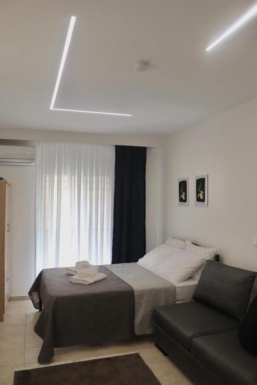 a bedroom with a bed and a couch at Dany's studio central xanthi in Xanthi