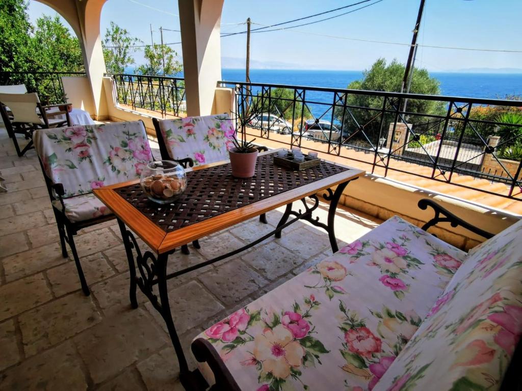 a table and chairs on a balcony with a view of the ocean at House M A R Y in Pefkali