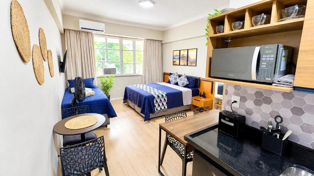 a small room with a bedroom and a bed and a kitchen at Flat Premium a 500m do aeroporto Santos Dumont & Consulados in Rio de Janeiro