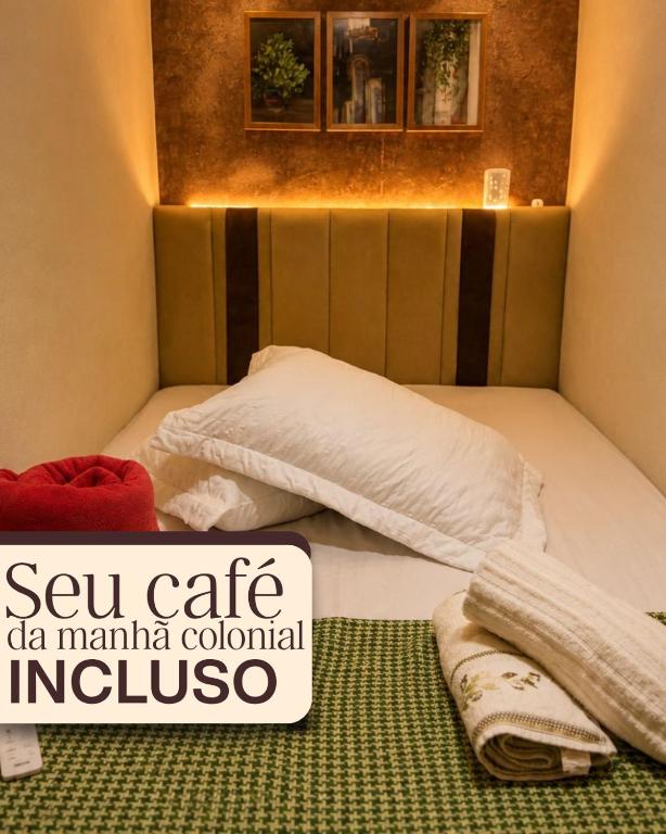 a bed with two towels on it with a sign on it at Ninho Moderno in Volta Redonda