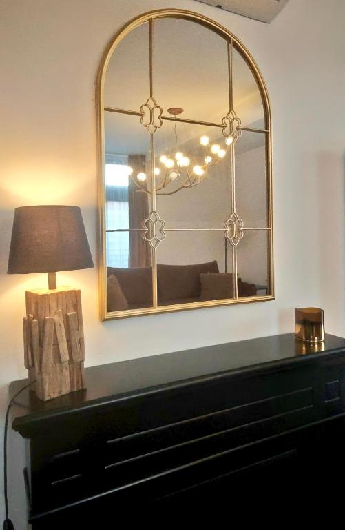 a mirror sitting on top of a dresser with a lamp at Loft Gryfita - butikowy blisko plaży, 2-poziomowy in Szczecinek