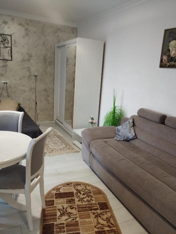 a living room with a couch and a table at Solid House - Sunrise Apartment in Mamaia