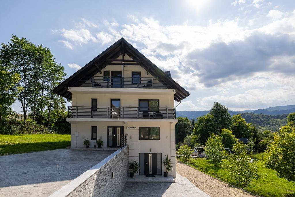 ein weißes Haus mit schwarzem Dach in der Unterkunft Arhondaric in Rucăr