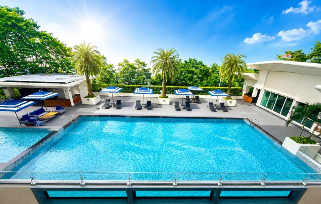 a pool on the roof of a hotel with chairs and a table at Centre Point Sukhumvit Thong-Lo in Bangkok