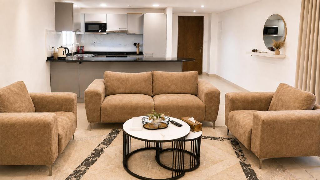 a living room with two couches and a table at Lake View By Bait Zain in As Sīfah