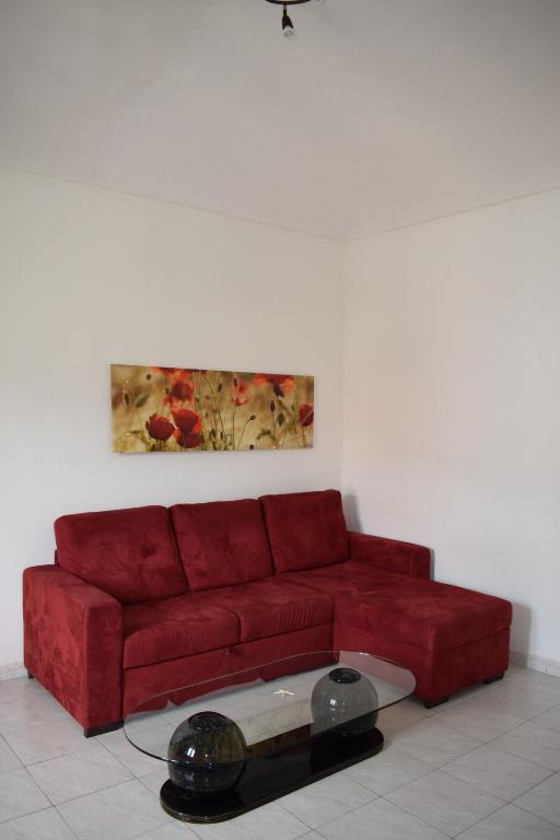 a red couch in a living room with a table at Appartamento Rubiana in Rubiana