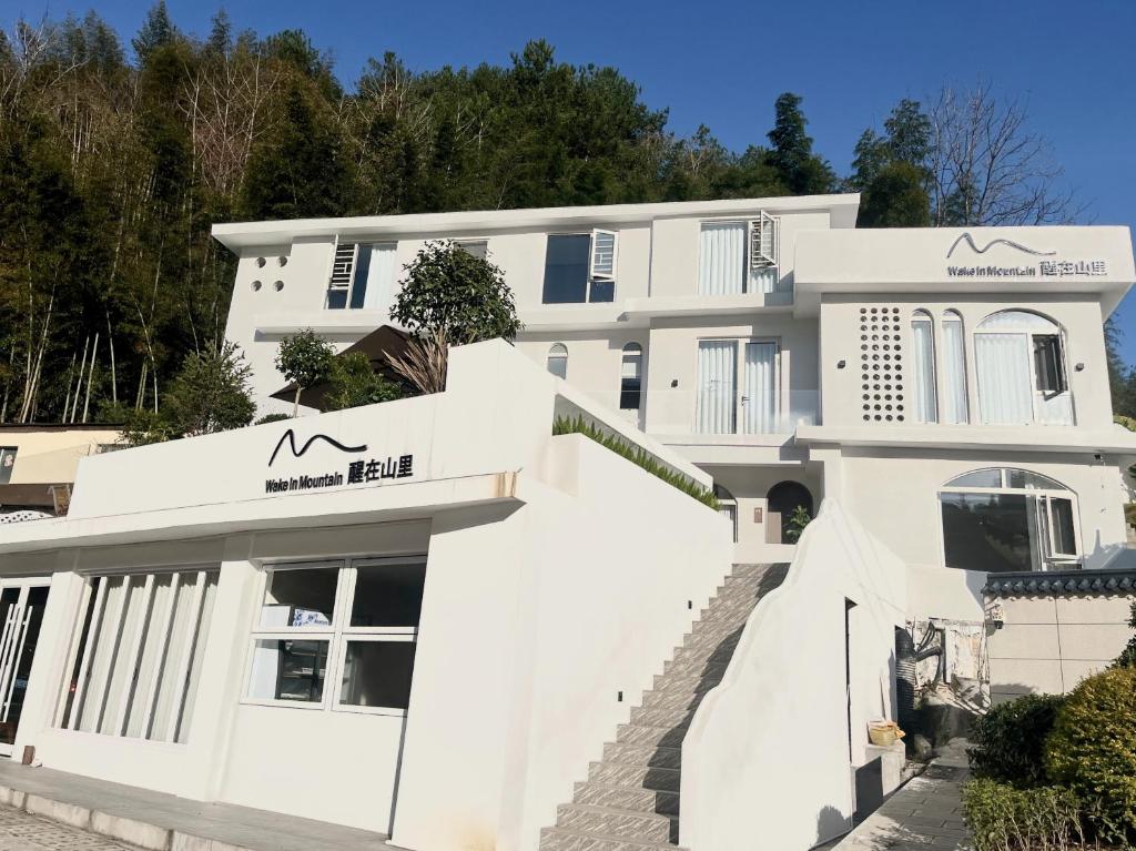 a large white building with a staircase in front of it at Book NOW & Chat, Wake in Mountain,Free Shuttle,Aside National Park, Combo Stay in Tianmen city center, English Speaking Assistant in Jiawan