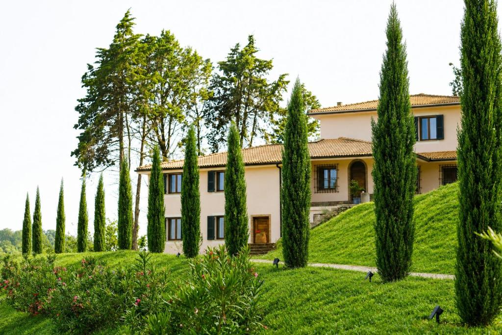 a large house with trees in front of it at Tenuta di Monte Gemini in Campagnano di Roma
