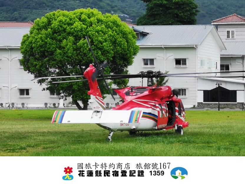 a red and white helicopter parked in a field at Oak Garden 國民旅遊卡特約商店 特斯拉免費充電 in Hualien City