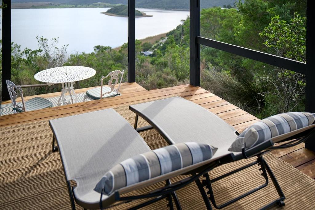 a deck with two chairs and a table on a balcony at Wish You Were Here! in Wilderness