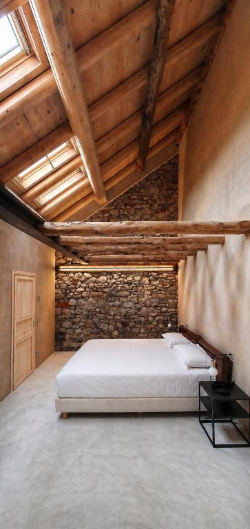 a bedroom with a bed in a brick wall at DIMORA STORICA ZACCHI D'ARRIGO in Belluno
