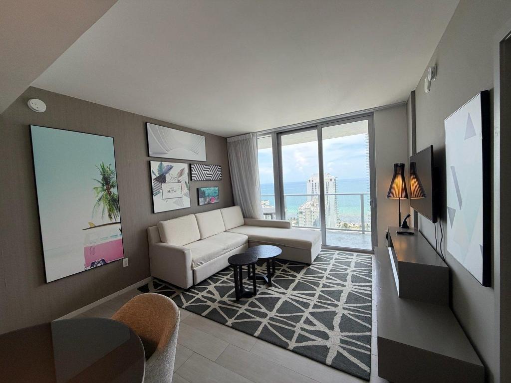 a living room with a white couch and a large window at Steps from the Beach - Amazing Views in Hollywood