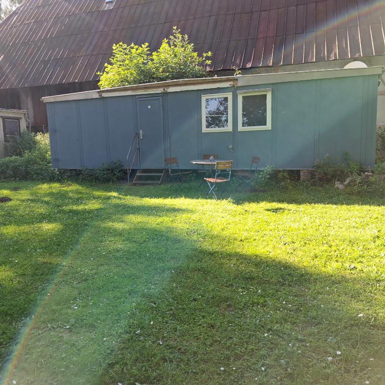 a green house with a table and chairs in a yard at casabandow in Schwaan