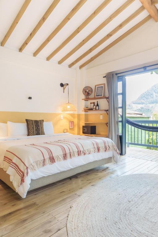 a bedroom with a large bed and a balcony at Hotel Plantación in Jardin