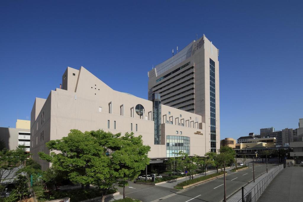 un gran edificio blanco en una ciudad con una calle en Kobe Seishin Oriental Hotel, en Kobe