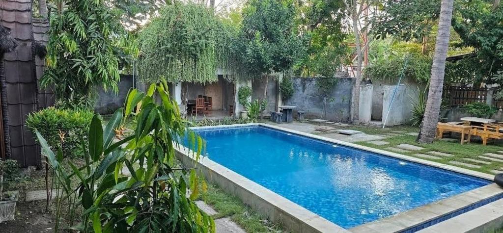 a large swimming pool in a yard with trees at Awang Homestay in Bumbang