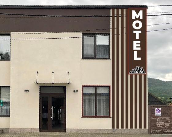 a white building with a sign on the side of it at Miraj House in Călăraşi