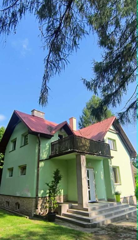 a green house with a red roof at Willa Baśka in Chańcza