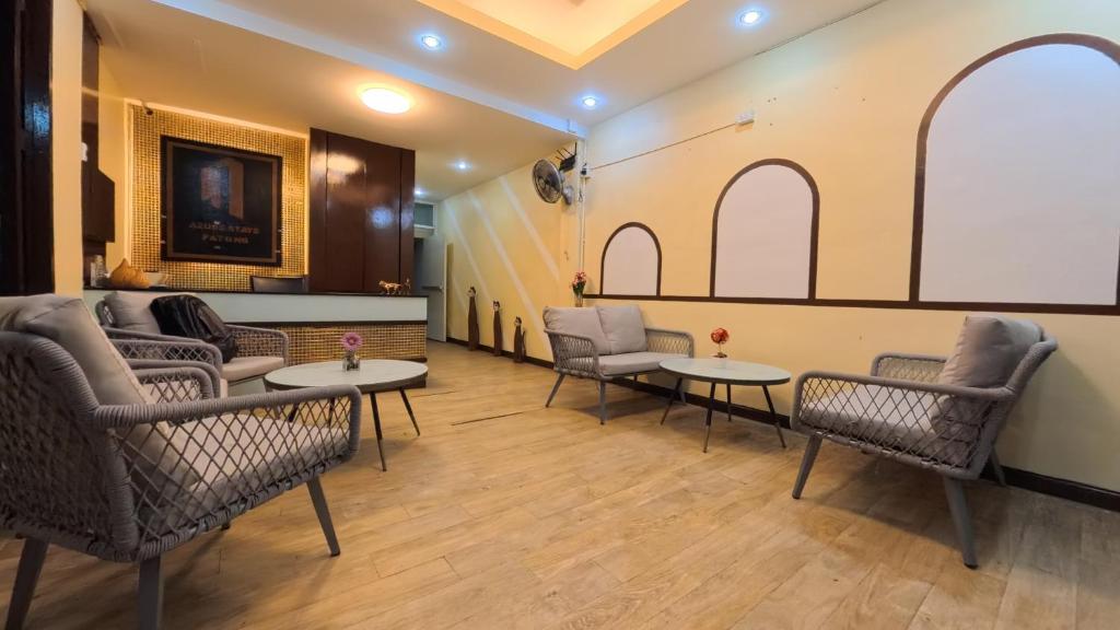 a waiting room with chairs and tables and a whiteboard at Azure Stays Patong in Patong Beach