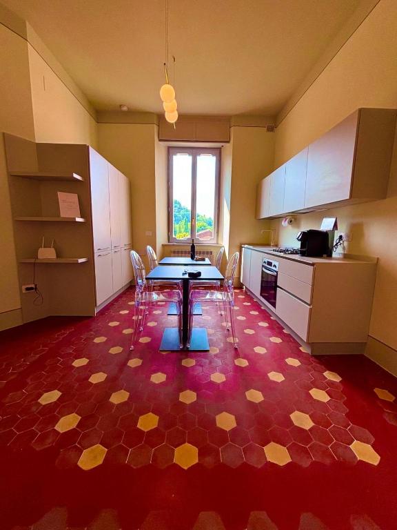 a kitchen with a table and chairs on a red floor at Augusta e Libero Apartments in Spoleto