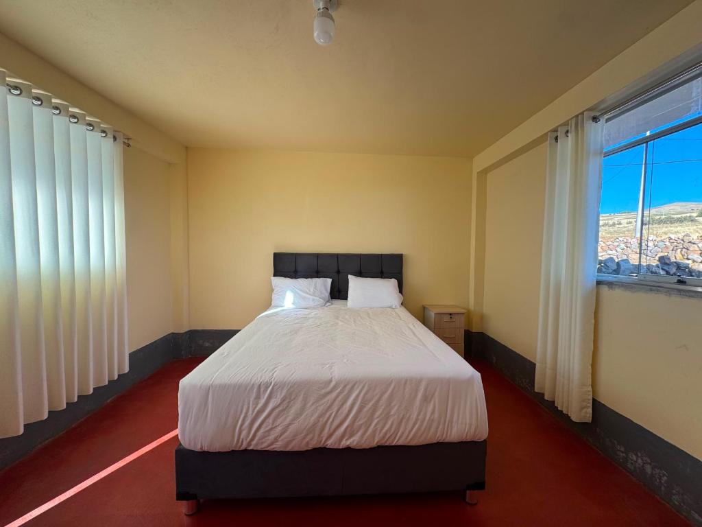 a bedroom with a bed and a large window at Casa Cóndor Ausangate in Tinke