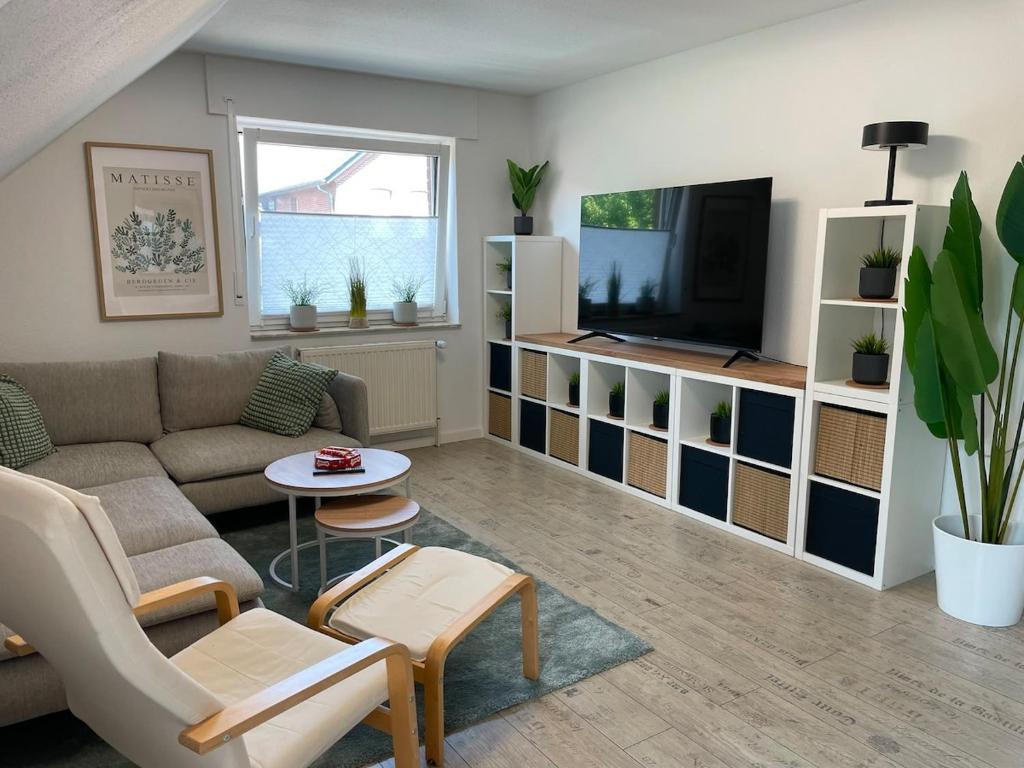 a living room with a couch and a tv at Deep Blue Dümmer - Apartment in Lembruch