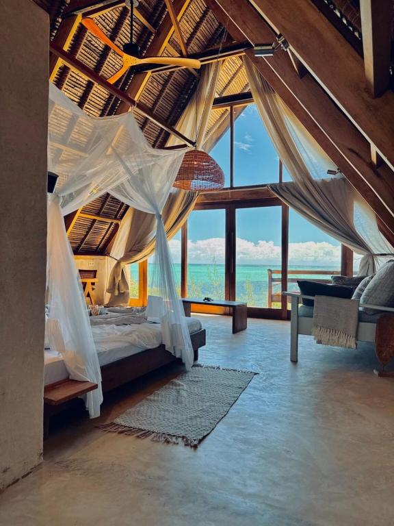 a bedroom with a bed with mosquito net at Tao Resort in Andavakonko