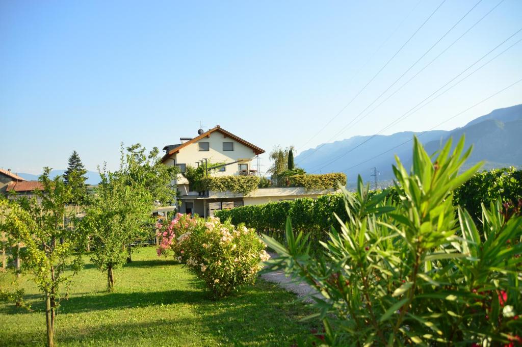 a house in a garden with mountains in the background at Ferienwohnungen Tollhof - Near Bolzano and castles, with a guest card for families and couples, offering panoramic views in Cornaiano