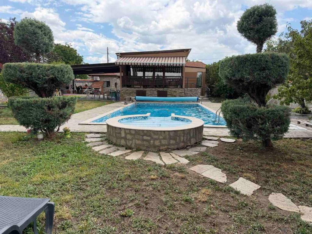 a swimming pool in the yard of a house at Divna Pool&Garden 