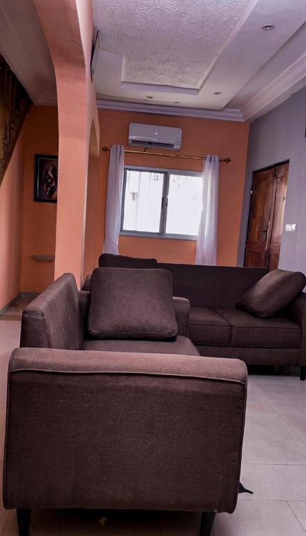 ein Wohnzimmer mit Sofa und Fenster in der Unterkunft Lavignon in Taméklo
