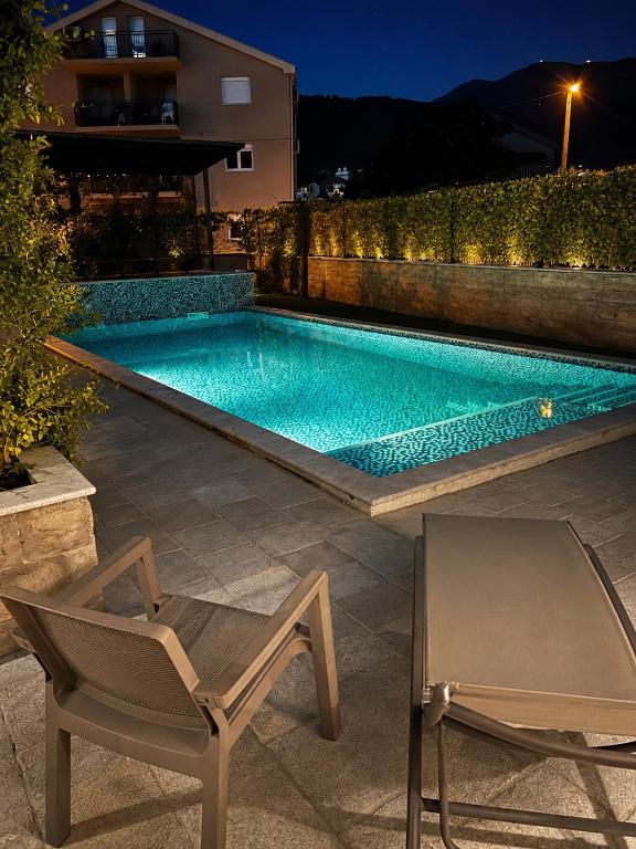 a swimming pool in a backyard with a chair and a chair at Apart-pool Tivat in Tivat