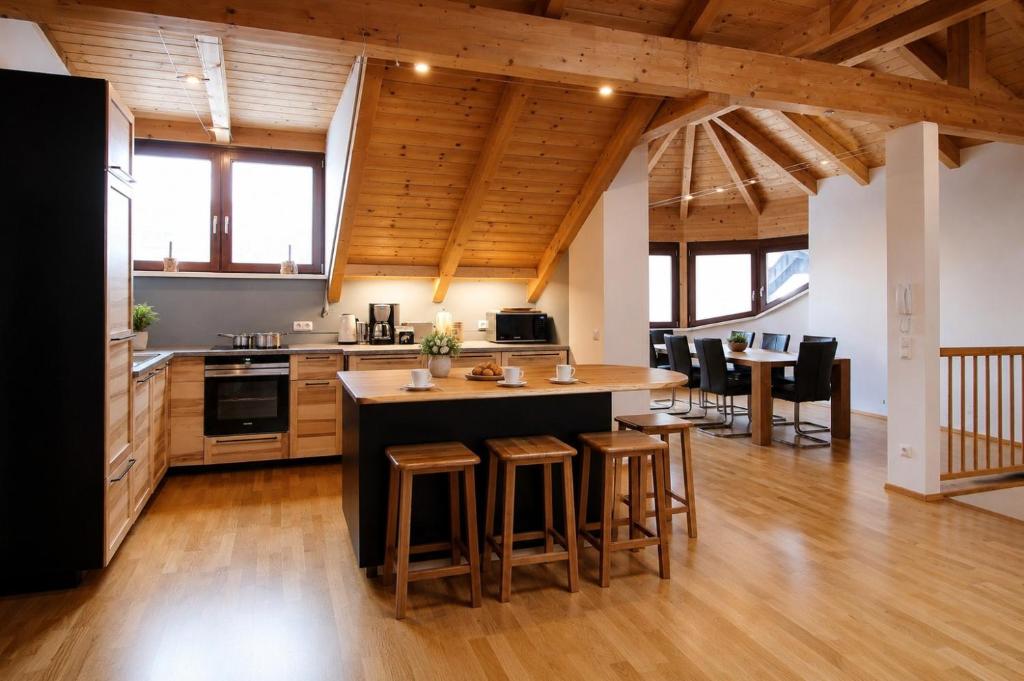 a kitchen with a large island with bar stools at Kelchalm Superior Spacious Mountain Apartment in Bad Kleinkirchheim