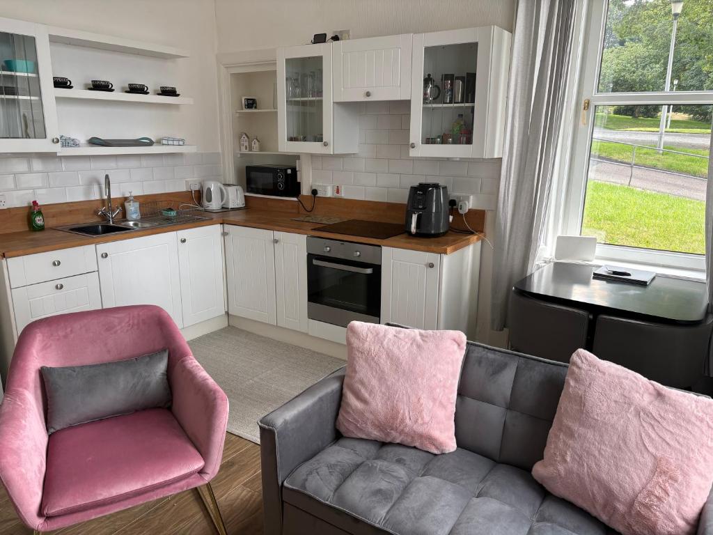 a living room with a couch and a kitchen at Our Wee Eden - Rothesay in Rothesay
