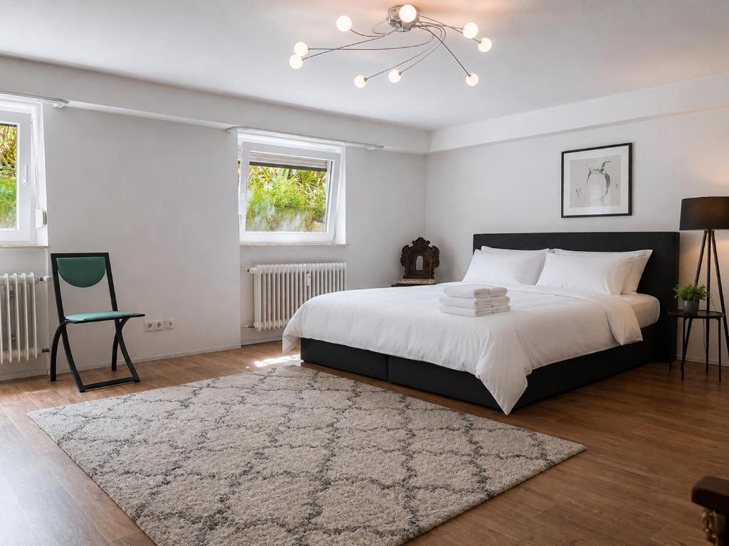 a bedroom with a large bed and a chair at Nest am Rhein in Öhningen